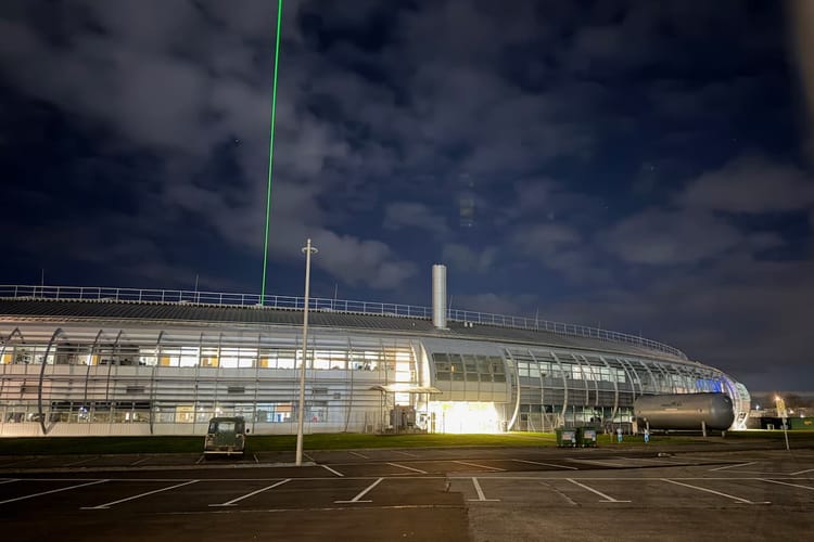 Mae pelydr laser gwyrdd yn disgleirio o'r Diamond Light Source